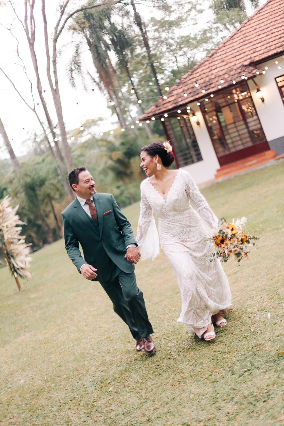 Casal caminhando no gramado do casarão