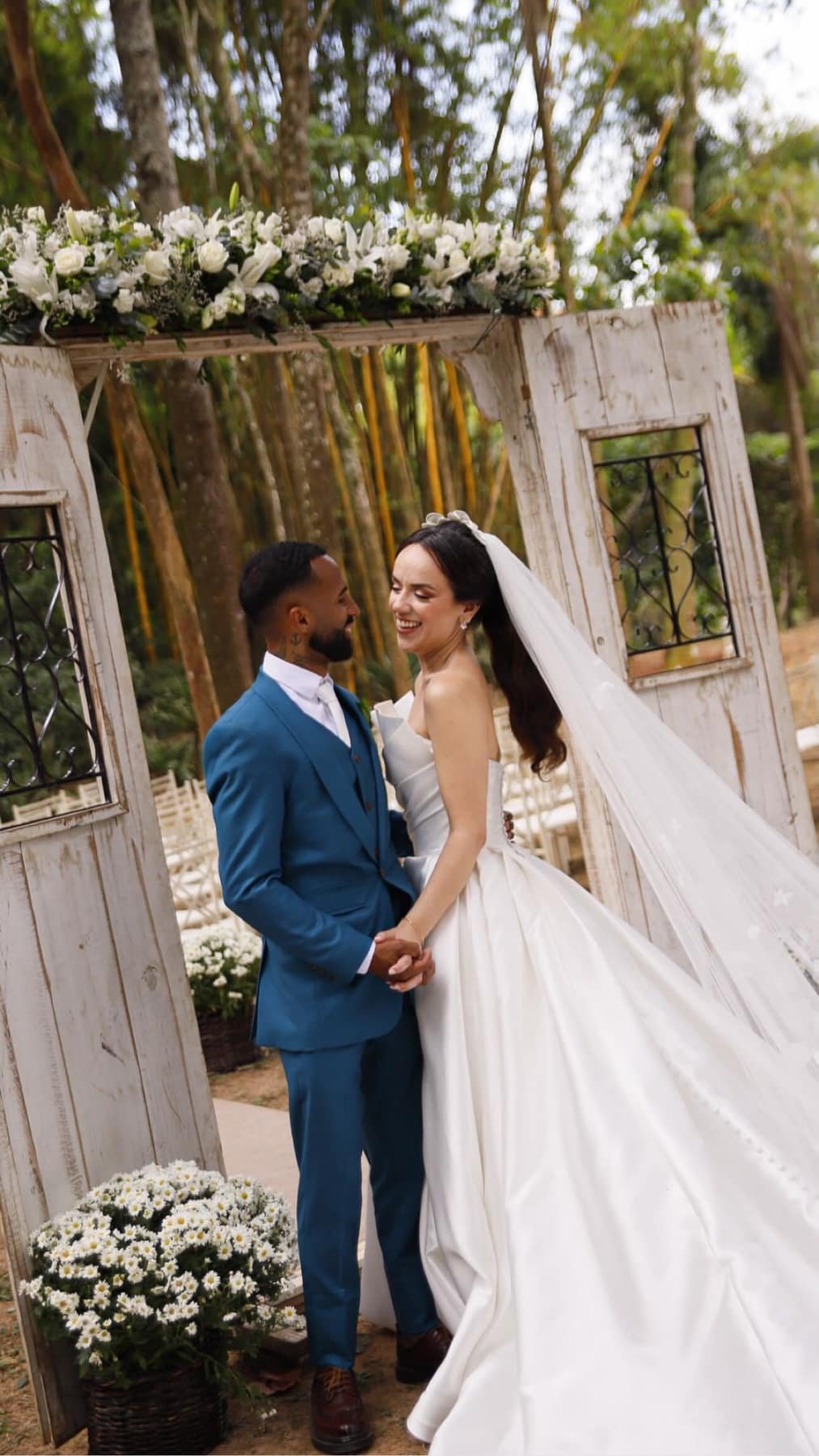 Casal diante das portas rústicas
