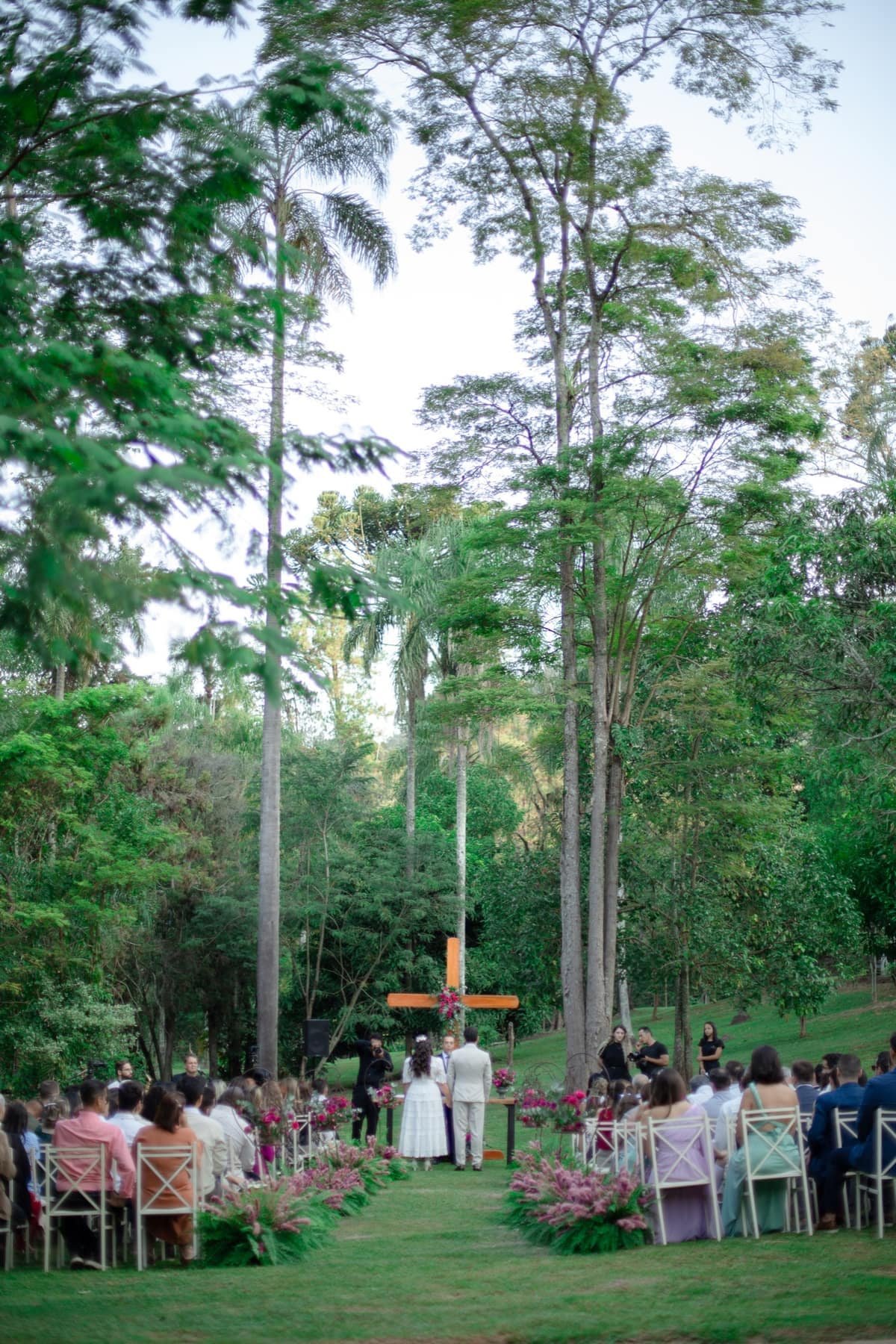 Cerimônia com cruz de madeira e jardim verde