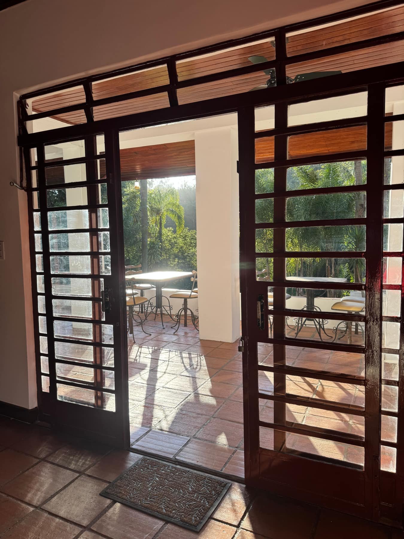 Portas do casarão abertas para a varanda com sol