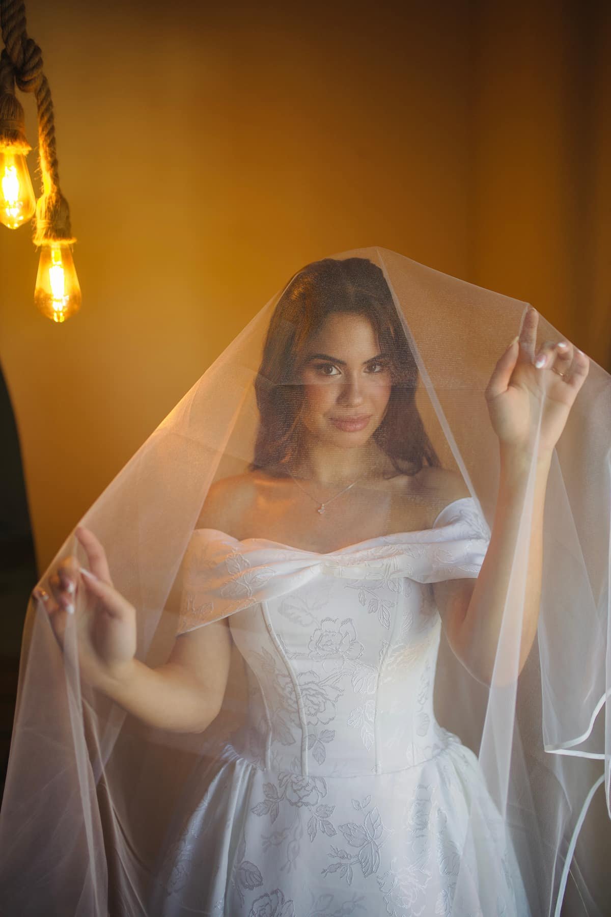 Noiva com véu em luz quente no making of