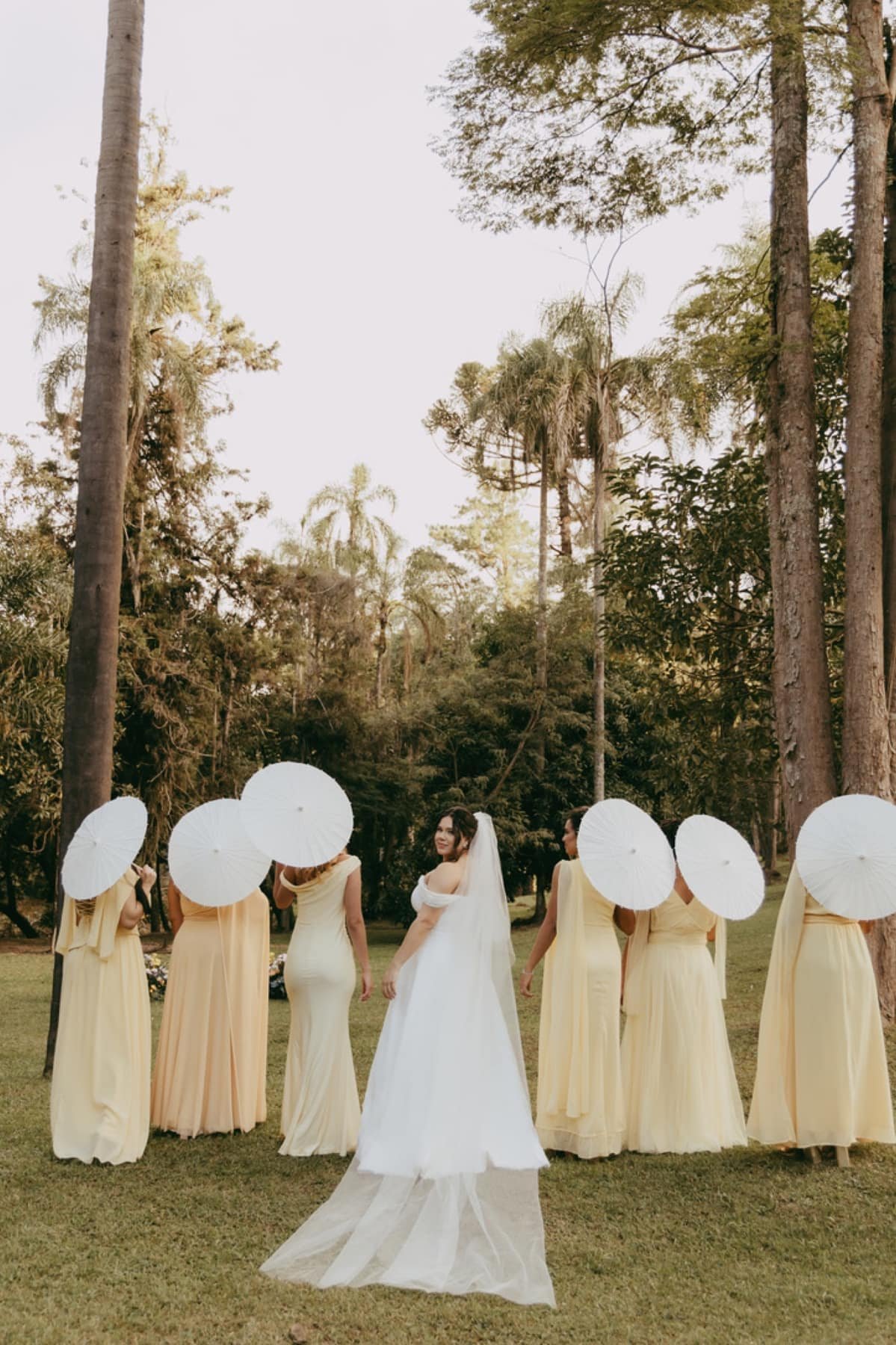 Noiva com madrinhas de amarelo no jardim da Fazenda Moinho