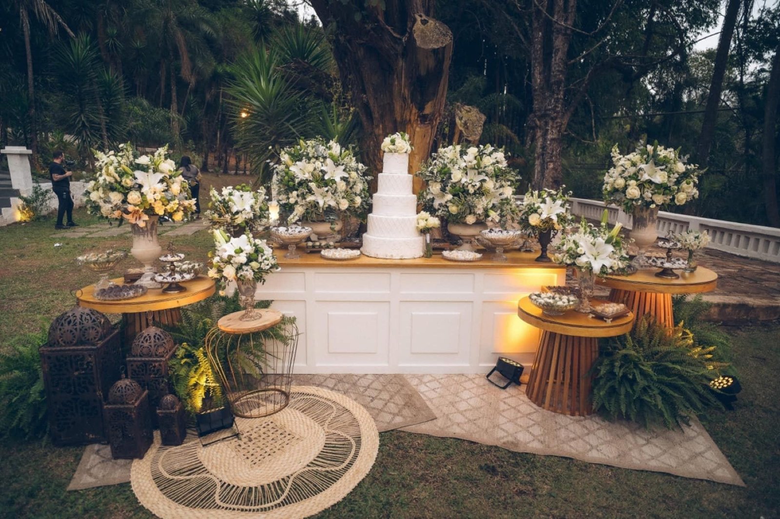 Mesa de bolo com flores brancas na recepção