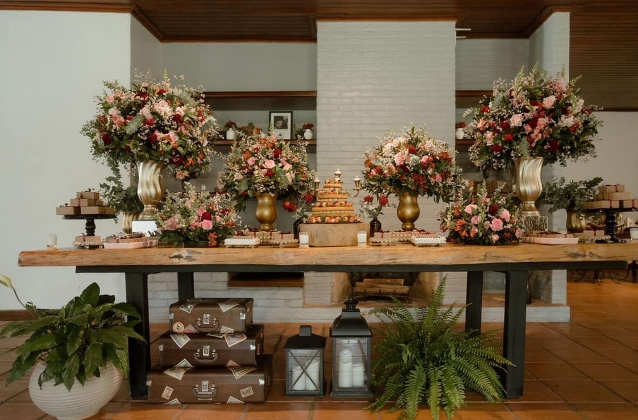 Mesa de doces com flores em tons rosados